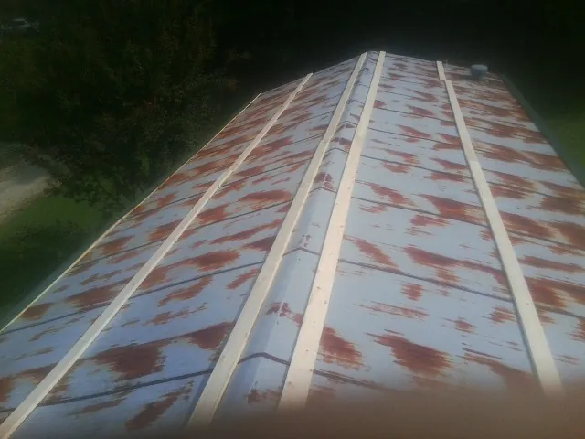 Rusted metal roof panels with new wood purlins before replacement — Storm Damage Roof Repair in Point Harbor by Roofing Brothers