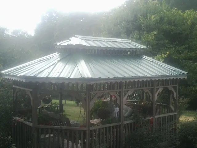 Two tier green metal roof on a garden gazebo in Point Harbor