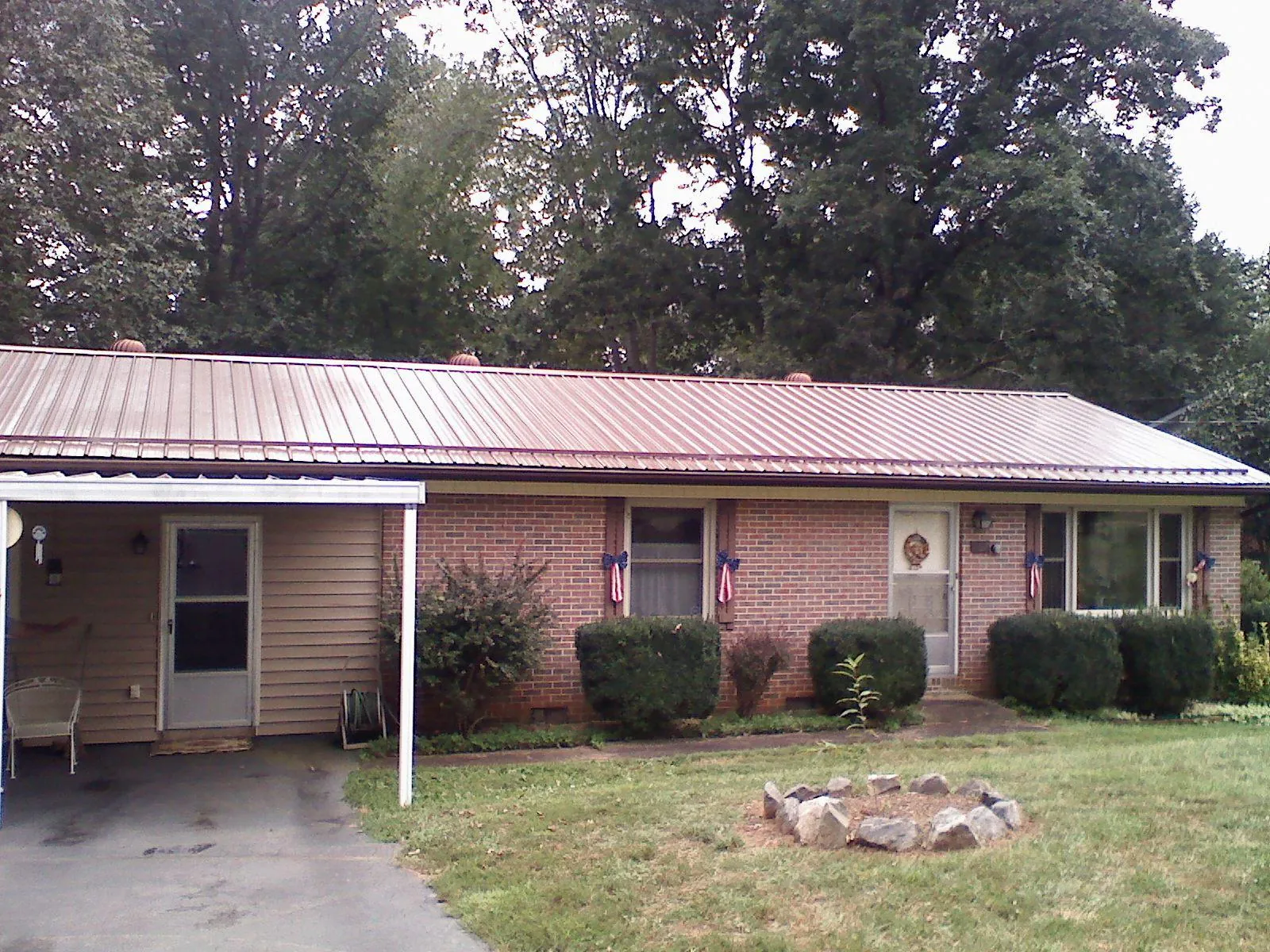 Bronze metal roof and carport on a brick ranch home — Roof Repair work by our crew in Point Harbor